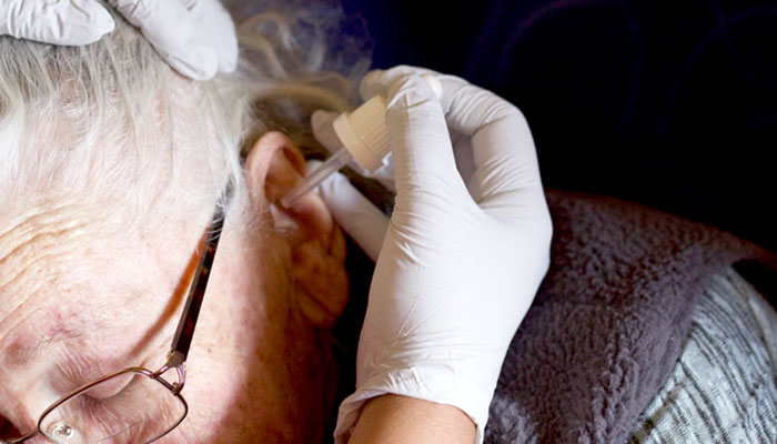 Squeezing dropper above ear