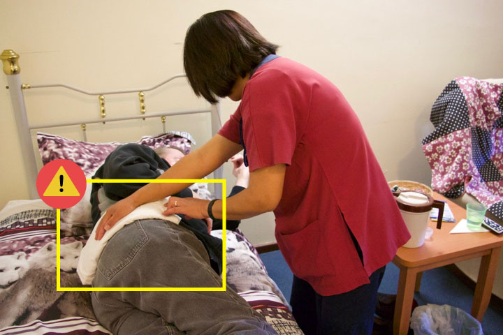 Jamie putting a heat pack on Ron's back